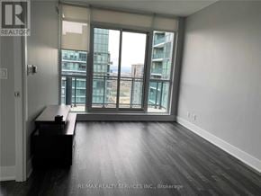 Mississauga (City Centre) condo for rent - A room with a desk and a window overlooking a cityscape.