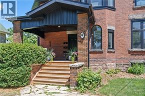 Brantford apartment for rent - A house with a brick facade and a wooden porch.
