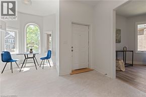 Brantford apartment for rent - A room with a white door and a table with blue chairs.