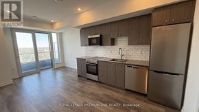 Kitchener condo for rent - A modern kitchen with stainless steel appliances and wooden cabinets.