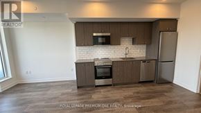Kitchener condo for rent - A kitchen with a refrigerator, oven, and microwave.