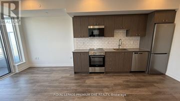 Kitchener condo for rent - A kitchen with brown cabinets and a white backsplash.