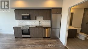 Kitchener condo for rent - A kitchen with a refrigerator, oven, and microwave.