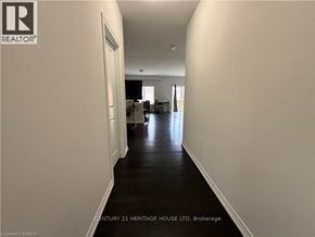 Brantford apartment for rent - A long hallway with a door on the left and a kitchen area in the distance.