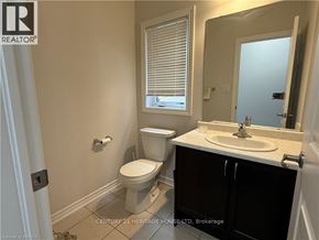 Brantford apartment for rent - A bathroom with a toilet, sink, and window.