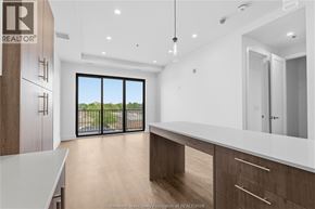 Windsor condo for rent - A modern kitchen with wooden cabinets and a large window.