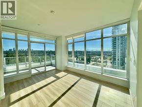 Burnaby apartment for rent - A spacious room with large windows overlooking a cityscape.