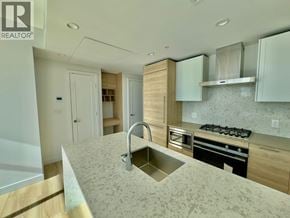 Burnaby apartment for rent - A modern kitchen with a sink, stove, and cabinets.