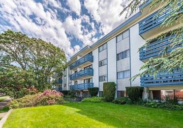Victoria apartment for rent - A modern apartment building with a well-maintained lawn and trees in the foreground.