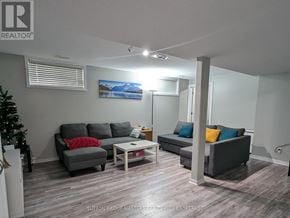 Kingston (Kingston East (Incl Barret Crt)) apartment for rent - A living room with a grey couch, a red pillow, and a painting of a lake.