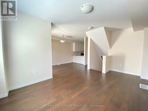 Hamilton (Meadowlands) townhouse for rent - A large empty room with wooden floors and white walls.