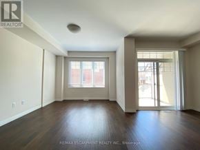 Hamilton (Meadowlands) townhouse for rent - A spacious room with wooden floors and a large window.