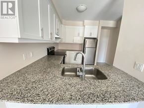 Hamilton (Meadowlands) townhouse for rent - A kitchen with granite countertops and white cabinets.