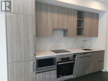 Toronto (Bayview Village) condo for rent - A modern kitchen with wooden cabinets and stainless steel appliances.