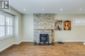 Toronto (Birchcliffe-Cliffside) apartment for rent - A stone fireplace in a room with wood floors and two paintings on the wall.