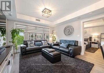 King (Schomberg) condo for rent - A modern living room with a black leather sofa set and a wooden floor.