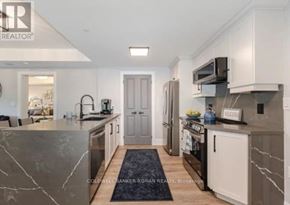 King (Schomberg) condo for rent - A modern kitchen with a marble countertop and a refrigerator.