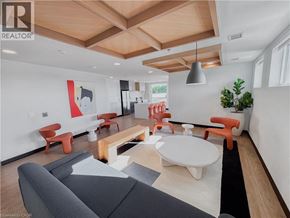 Kitchener condo for rent - A living room with a grey couch and orange chairs.