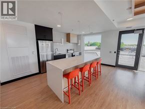 Kitchener condo for rent - A modern kitchen with a white island and red bar stools.
