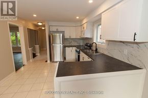 Aurora (Bayview Wellington) apartment for rent - A kitchen with white cabinets and a black countertop.