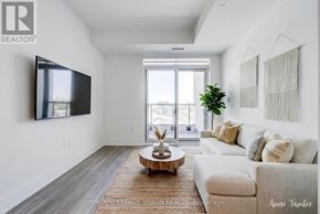 Toronto (Dovercourt-Wallace Emerson-Junction) condo for rent - A living room with a white couch and a flat screen TV mounted on the wall.