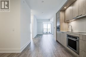Toronto (Dovercourt-Wallace Emerson-Junction) condo for rent - A spacious kitchen with wooden cabinets and a stainless steel oven.