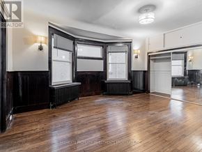Toronto (Palmerston-Little Italy) apartment for rent - A room with wooden floors and black walls.