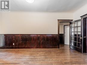 Toronto (Palmerston-Little Italy) apartment for rent - A room with a wooden floor and a dark brown wall.
