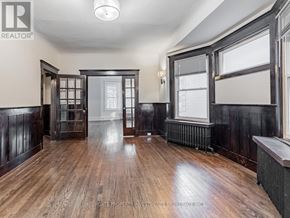 Toronto (Palmerston-Little Italy) apartment for rent - A room with wooden floors and dark walls, with a window on the right side.