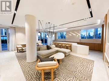 Toronto (Regent Park) condo for rent - A living room with a large rug and a wooden chair.