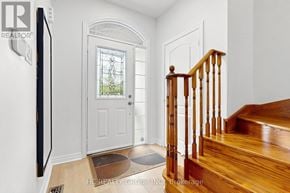 Newmarket (Woodland Hill) apartment for rent - A wooden staircase with a white door and a window in the background.