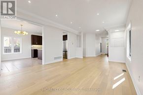 Newmarket (Woodland Hill) apartment for rent - A spacious, well-lit room with wooden floors and white walls, featuring a kitchen area with a refrigerator, cabinets, and a dining table.