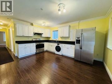 Vancouver apartment for rent - A kitchen with white cabinets and a stainless steel refrigerator.