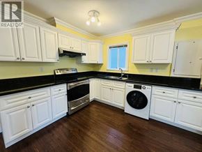Vancouver apartment for rent - A kitchen with white cabinets and black countertops.