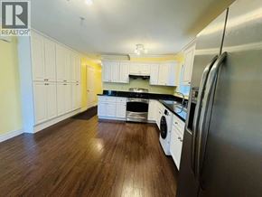 Vancouver apartment for rent - A kitchen with white cabinets and a wooden floor.