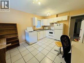 Vancouver apartment for rent - A kitchen with white appliances and a black chair.
