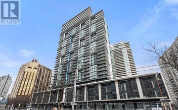 Toronto (Willowdale East) condo for rent - A tall building with a glass facade stands in front of other buildings.