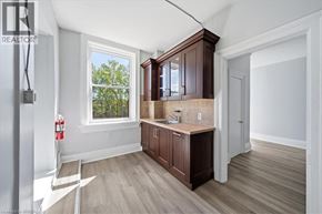 Paris apartment for rent - A well-lit kitchen with wooden cabinets and a window.