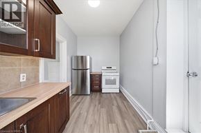 Paris apartment for rent - A kitchen with wooden cabinets and a stainless steel refrigerator.