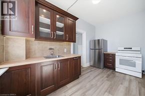Paris apartment for rent - A kitchen with wooden cabinets and a stainless steel refrigerator.