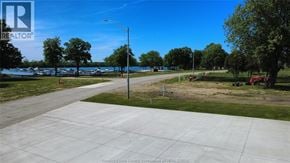 Amherstburg townhouse for rent - A realtor image of a driveway leading to a grassy area with trees.