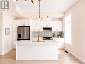 Richmond Hill townhouse for rent - A modern kitchen with white cabinets and a central island.