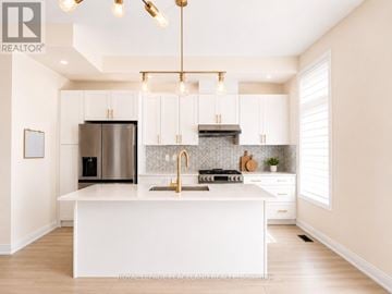 Richmond Hill townhouse for rent - A modern kitchen with white cabinets and a central island.