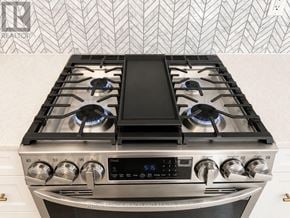 Richmond Hill townhouse for rent - A modern gas stove with a digital display and control knobs.