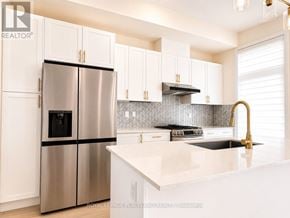 Richmond Hill townhouse for rent - A modern kitchen with a stainless steel refrigerator and white cabinets.