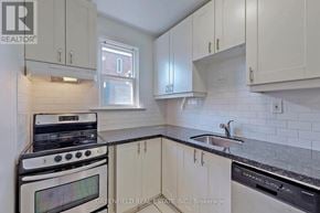 Toronto (Leaside) fourplex for rent - A kitchen with white cabinets and a black dishwasher.