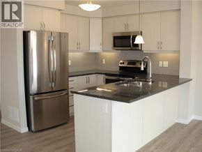 Kitchener townhouse for rent - A kitchen with a refrigerator, microwave, and sink.