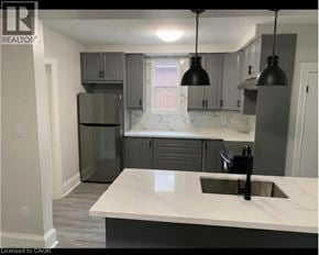 Hamilton apartment for rent - A kitchen with a marble countertop and grey cabinets.