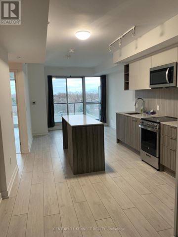 Toronto (Clanton Park) condo for rent - A kitchen with a wooden island and a microwave above it.