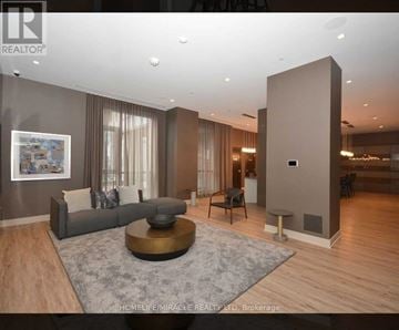 Mississauga (Hurontario) condo for rent - A modern living room with a grey sofa and a coffee table.